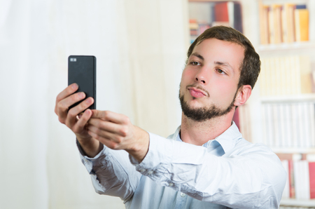 attractive young  casual using cell phone to take a selfieの写真素材