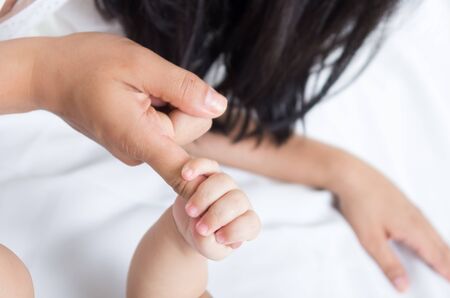 closeup shot of babys hand holding her mothers finger tightの写真素材