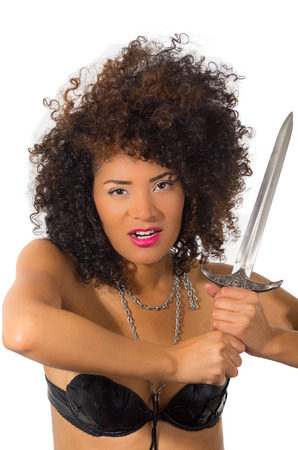 beautiful exotic young tribal woman holding a dagger in a combat pose isolated on whiteの写真素材