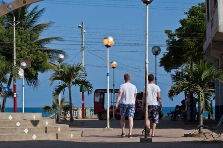 MANABI, ECUADOR - JUNE 6, 2012: Unidentified tourists walking in the main street of touristic town of Puerto Lopezのeditorial素材