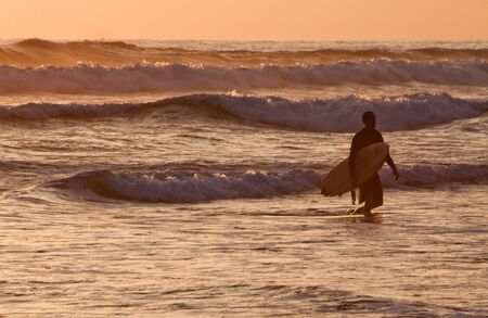 MANABI, ECUADOR - JUNE 5, 2012: Unidentified tourist surfer enjoying the sea during sunset in the town of Puerto Lopez.のeditorial素材