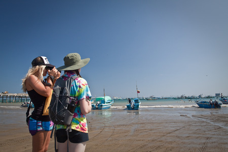 MANABI, ECUADOR - JUNE 4, 2012: Unidentified tourists enjoying the ocean view in a fishing town beach.のeditorial素材