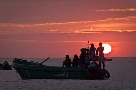 MANABI, ECUADOR - JUNE 3, 2012: Beautiful landscape view of floating fishing boat silhouette with amazing sunset in the background, Manabi, Ecuadorのeditorial素材