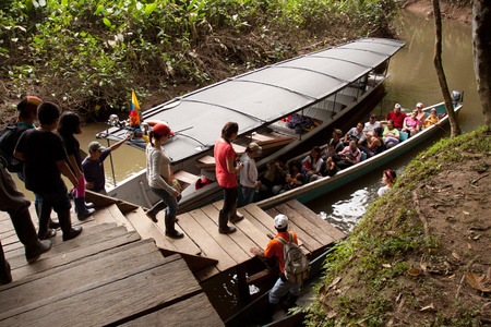 ORELLANA, ECUADOR - AUGUST 12, 2012: Unidentified tourists boarding a canoe to go on a tour along the Napo river in the amazon rainforest, Yasuni National Park, Orellana, Ecuadorのeditorial素材