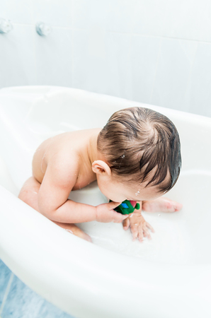 Close up portrait of sweet baby boy in the bathtubの写真素材