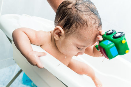 Close up portrait of playful baby boy in the tub