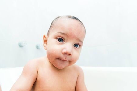Close up portrait of sweet baby boy in the bathtubの写真素材