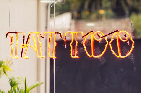 Tattoo letters with burning flame design hanging in windowの写真素材