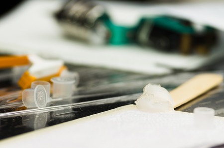 Tattoo accessories like plastic caps, razor on table in a pileの写真素材