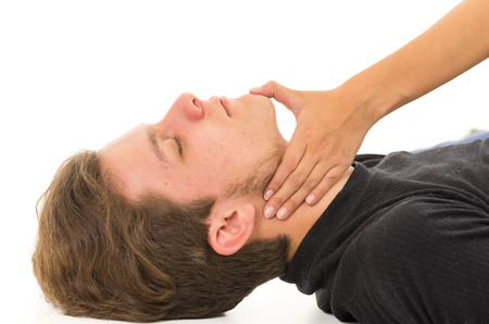 Couple demonstrating first aid techniques with male patients head being tilted slightly backwards by female hand.の写真素材