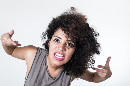 Headshot hispanic brunette model with messy makeup and hair looking for trouble expression into camera, white background.の写真素材