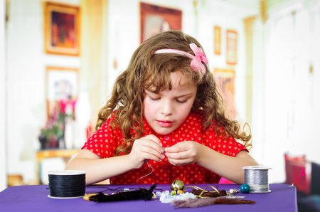 Adorable little girl making crafts at homeの写真素材