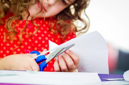 Little girls' hands using scissors, closeup shotの写真素材
