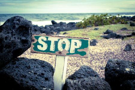 old wooden stop sign warning about a protected beach area in santa cruz galapagos islandsの写真素材