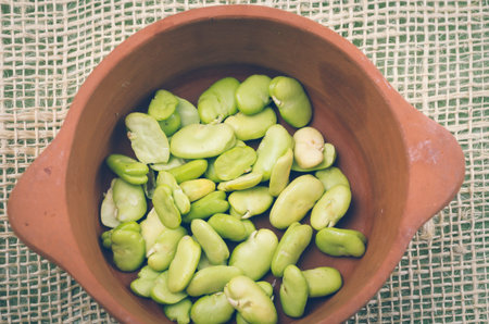 lima beans inside ceramic terracota bowl and rustic background.