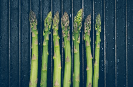 Bunch of asparagus on black metal background grill.の写真素材