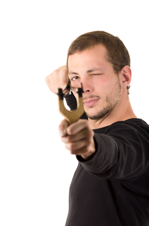 Hansome man concentrated aiming a slingshot isolated over white background.の写真素材