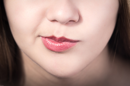Closeup of pretty young girl's mouth expressing suspicionの写真素材