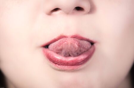 Closeup of pretty young girl's mouth with tongue outの写真素材