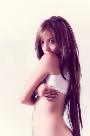 Portrait of attractive young sensual hispanic woman wearing a small top looking at cameraの写真素材