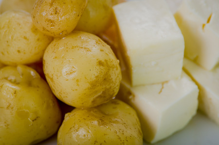 Closeup freshly prepared balls of green banana and pieces fresh cheese on white plate.の写真素材