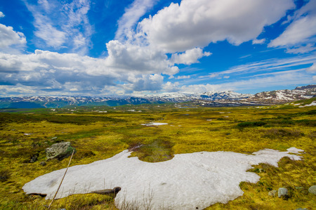VALDRES, NORWAY - 6 JULY, 2015: Stunning nature on Valdresflya, green covered landscape stretches far as eye can see with spots of snow and lakes under beautiful blue sky.のeditorial素材