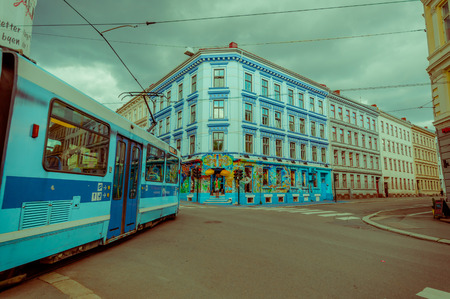 OSLO, NORWAY - 8 JULY, 2015: Tram passing through Grunerlokka neighbourhood next to Birkelunden park, Scorpius exotic store visible in front.のeditorial素材