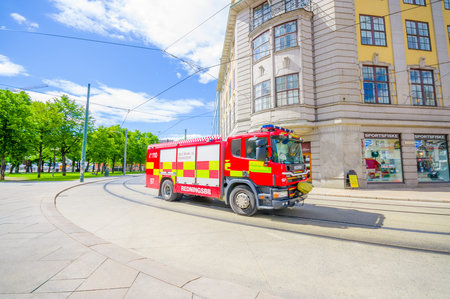 OSLO, NORWAY - 8 JULY, 2015: Red firetruck passing by in Fred Olsensgate on a beautiful sunnt day.