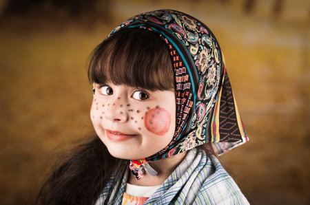 Portrait of beautiful little girl dressed as a traditional finnish easter witch with headscarf and...