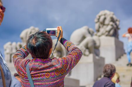 OSLO, NORWAY - 8 JULY, 2015: Tourists enjoying a beautiful sunny day in the famous Vigelandsparken which contains numerous nude sculptures.のeditorial素材