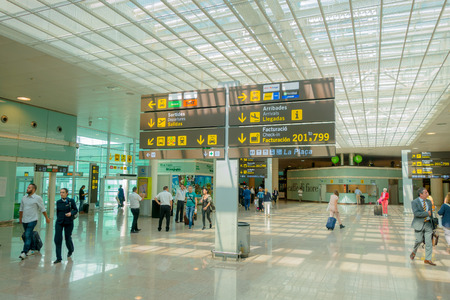 BARCELONA, SPAIN - 8 AUGUST, 2015: Inside arrivals terminal walking through building with signs and information around at airport.のeditorial素材