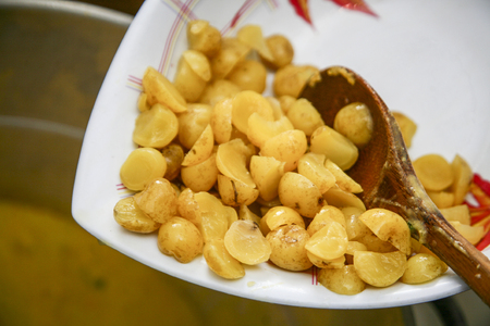 Closeup white bowl of cooked olluco with wooden spoon lying inside, preparing fanesca concept.の写真素材