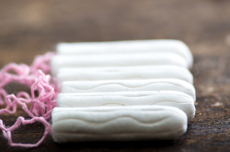 Clean white tampons lying on wooden surface.の写真素材