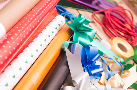 Gift wrapping concept with various paper colors, scissors, tape and other decoratives lying on...