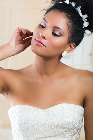 Portrait of stunning curly exotic bride wearing white dressの写真素材