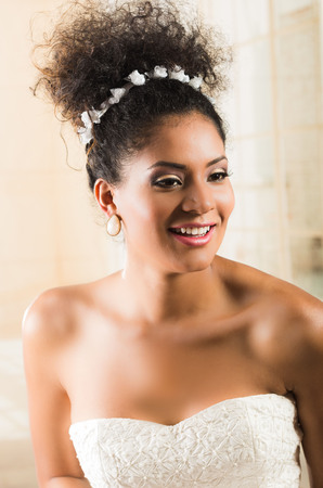 Portrait of stunning curly exotic bride wearing white dressの写真素材
