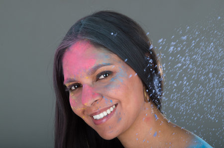 Beautiful young brunette girl with colorful decorated face celebrating