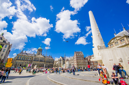Amsterdam, Netherlands - July 10, 2015: Dam Square on a beautiful sunny day, tall monument and historical buildings around plaza.のeditorial素材