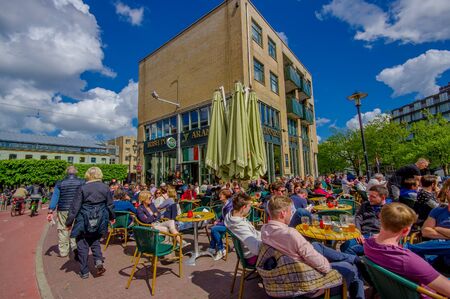 Amsterdam, Netherlands - July 10, 2015: Typical outdoors street restaurant with people soaking in the sun and drinking beer.のeditorial素材
