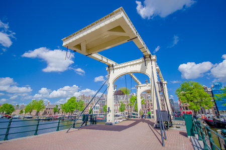 Amsterdam, Netherlands - July 10, 2015: Old metal bridge with beautiful design, stretching across one of many water channels.のeditorial素材