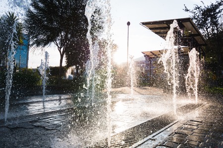 Modern and beutifull waterfall with sun in the back. Water drops dancing in a big splash with threes in the backの写真素材