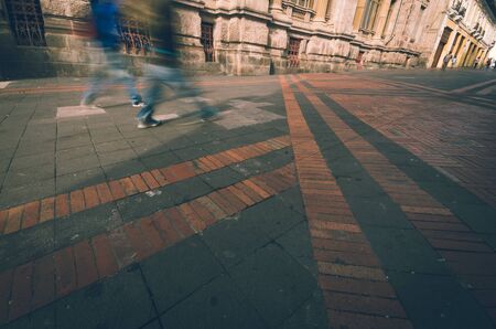 Brick and stone street in historical center, red and black colors blended, fast walking in sepia filterの写真素材