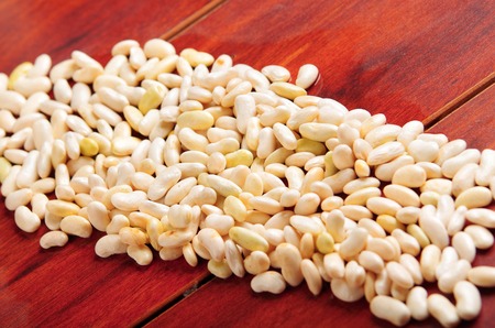 Lots of peeled lima beans lying spread out over wooden surface.の写真素材