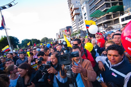 Quito, Ecuador - April 7, 2016: Group of people Holding protest signs, balloons with police and journalists during anti government protests in Shyris Avenue.のeditorial素材