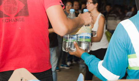 Quito, Ecuador - April 23, 2016: Volunteers of Quito providing disaster relief food, clothes, medicine and water for earthquake survivors in the coast. Gathered at Bicentenario Park.のeditorial素材