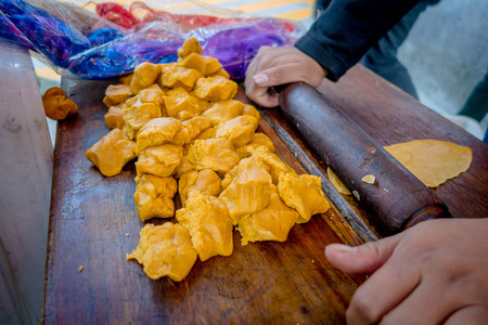 Various pieces of dough on a table and someone is rolling each one, flat pieceの写真素材