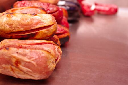 Beef sausage close up served in a metalic well, behind blood sausages,の写真素材