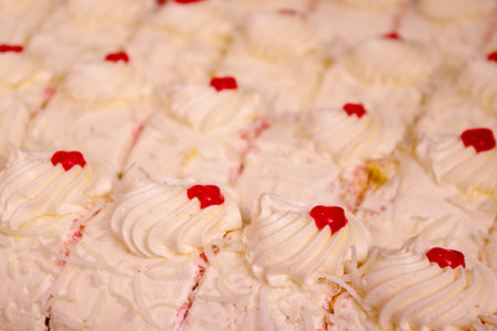 Dessert close up of delicious coconut and cream cake with sweet cherryの写真素材