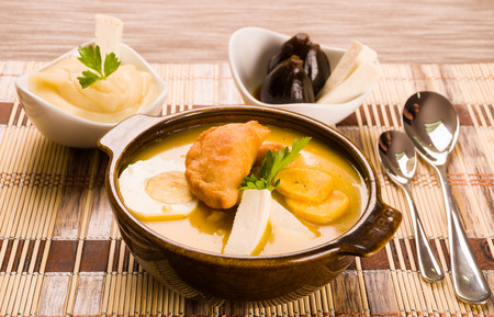 Elegant table setting with full serving of traditional fanesca soup and accessories.の写真素材