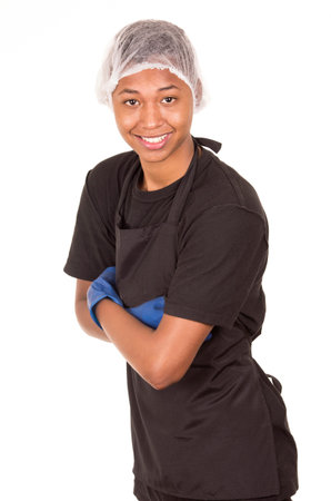Hispanic young man wearing blue cleaning gloves and plastic showercap standing with arms crossed smiling to camera.の写真素材